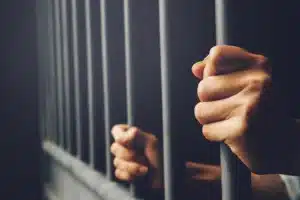 Hands behind bars in jail