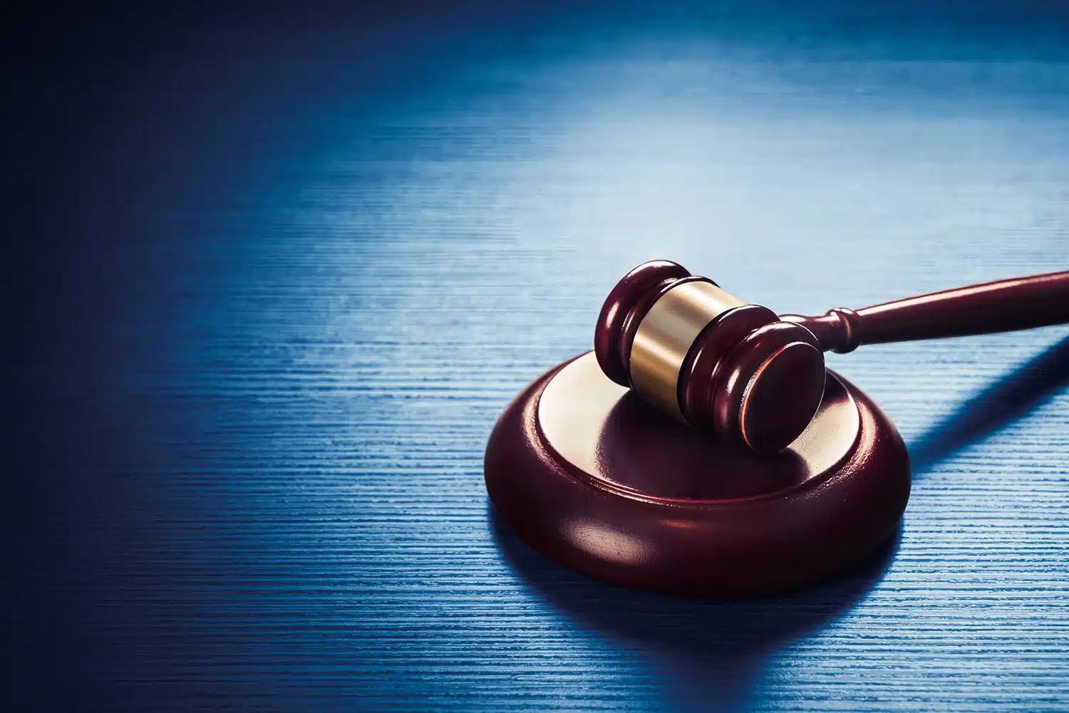 Gavel on a desk with dramatic blue lighting