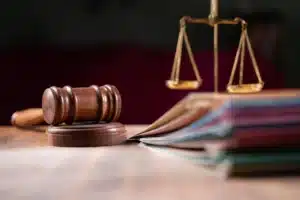 Gavel, scales, and notebooks on a table