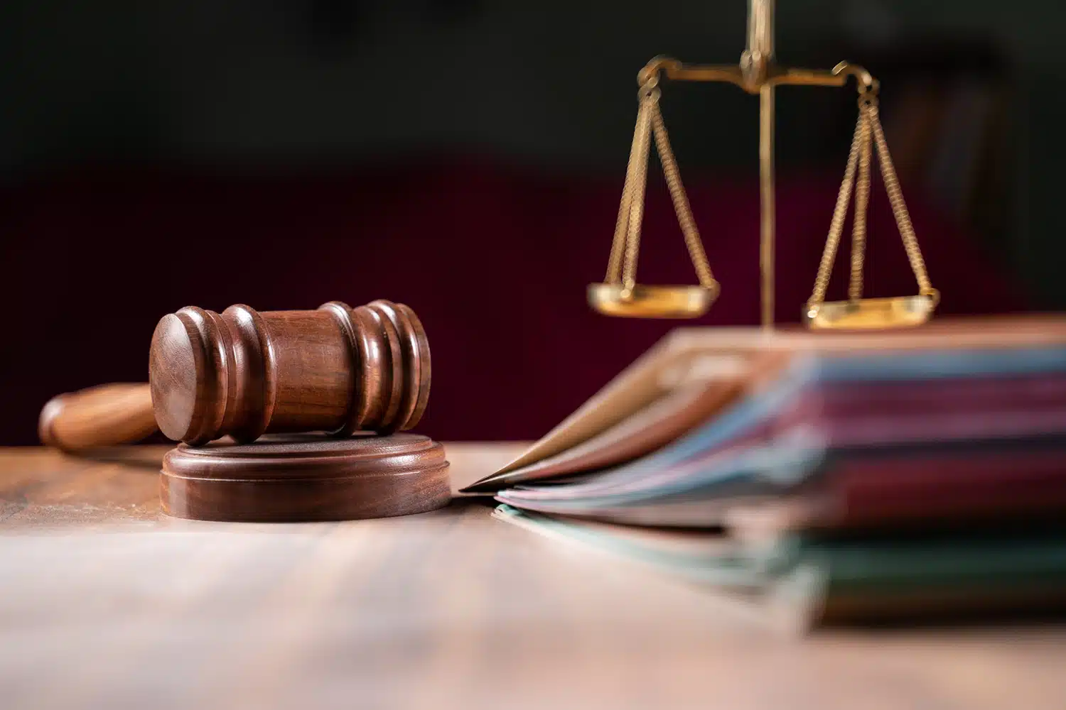 Gavel, scales, and notebooks on a table