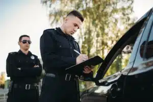 Police filling out clipboard while conducting traffic stop