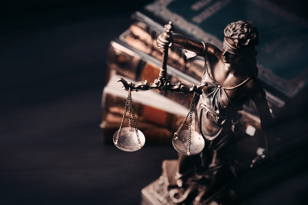 Lady of justice next to legal texts