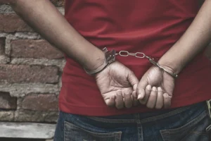 Man cuffed with hands behind back
